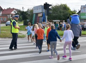 Zdjęcie przedstawia policjantów i dzieci z Inspektorkiem Kraśniczkiem.