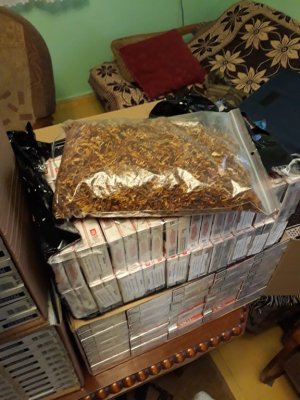Zdjęcie przedstawia pudełka z papierosami oraz worek z tytoniem.