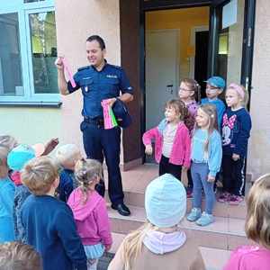 Policjant wręcza odblaski dzieciom